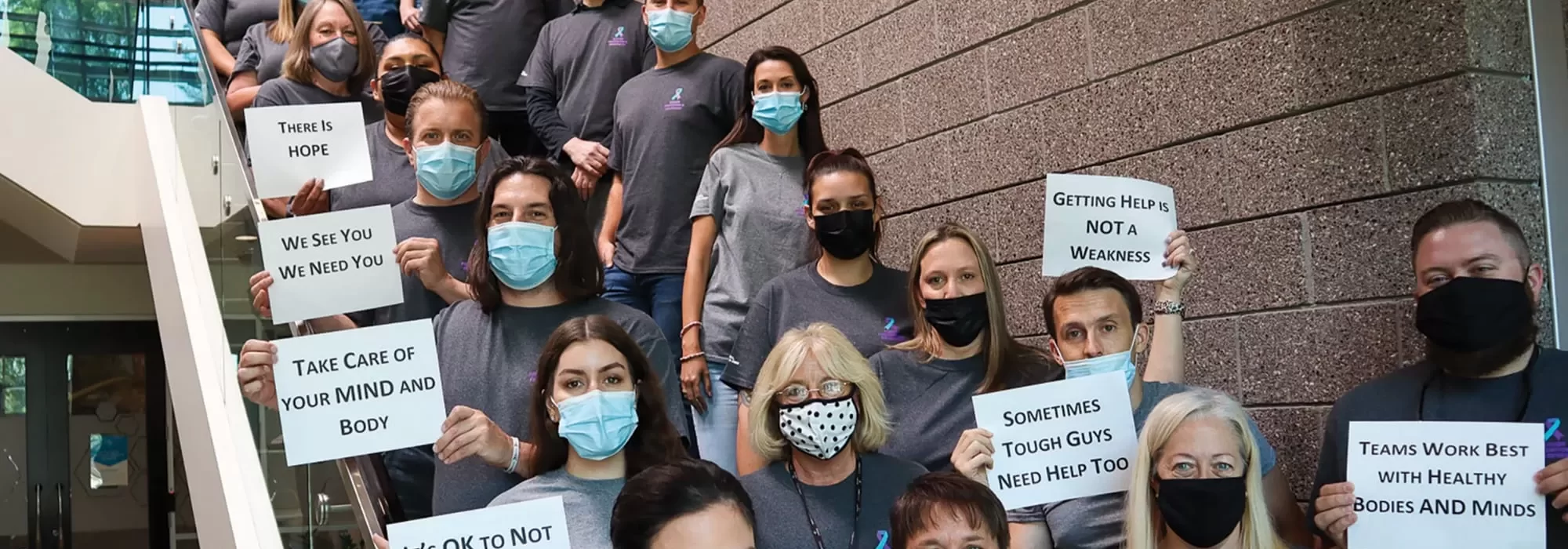 Workers wearing masks and holding signs