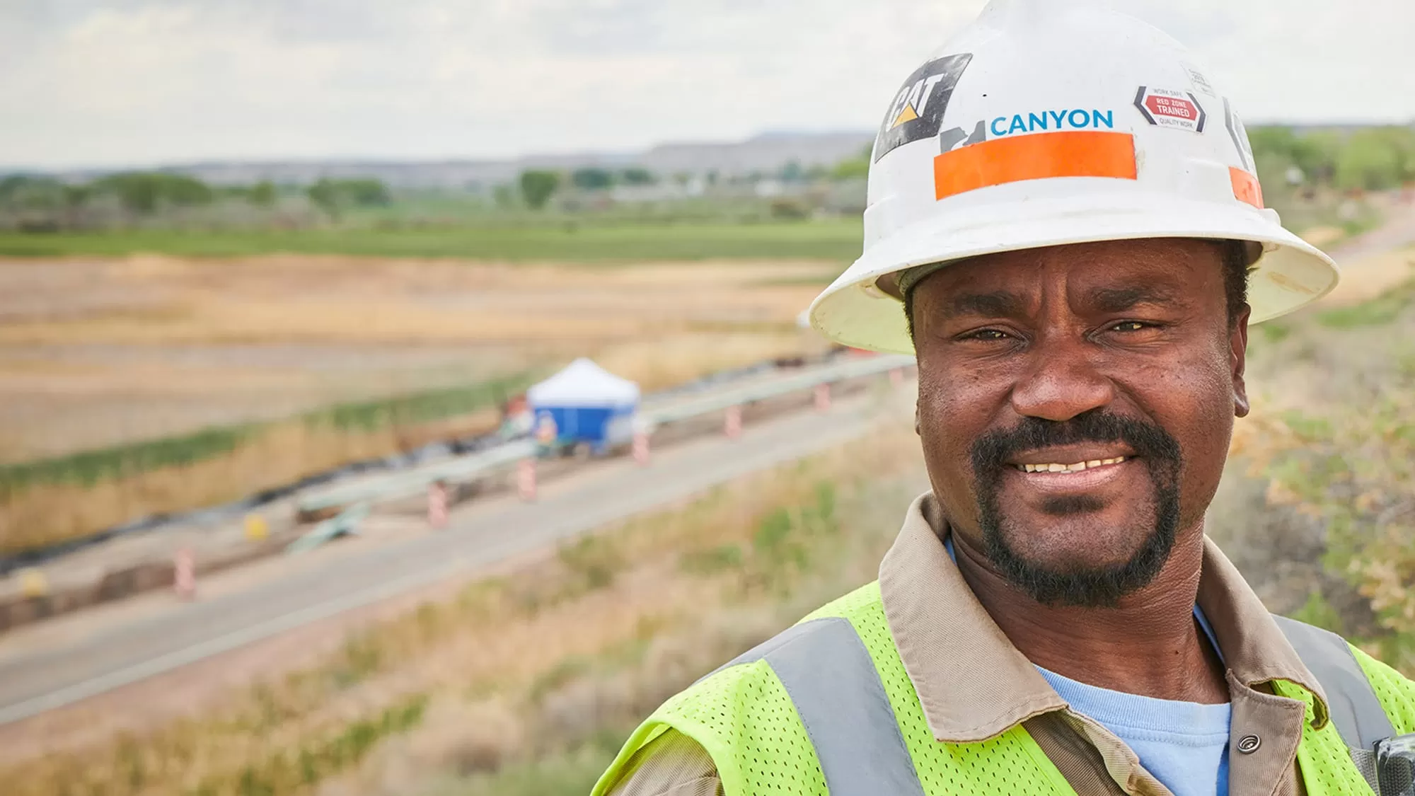 Canyon Pipeline worker smiling for the camera on a work site