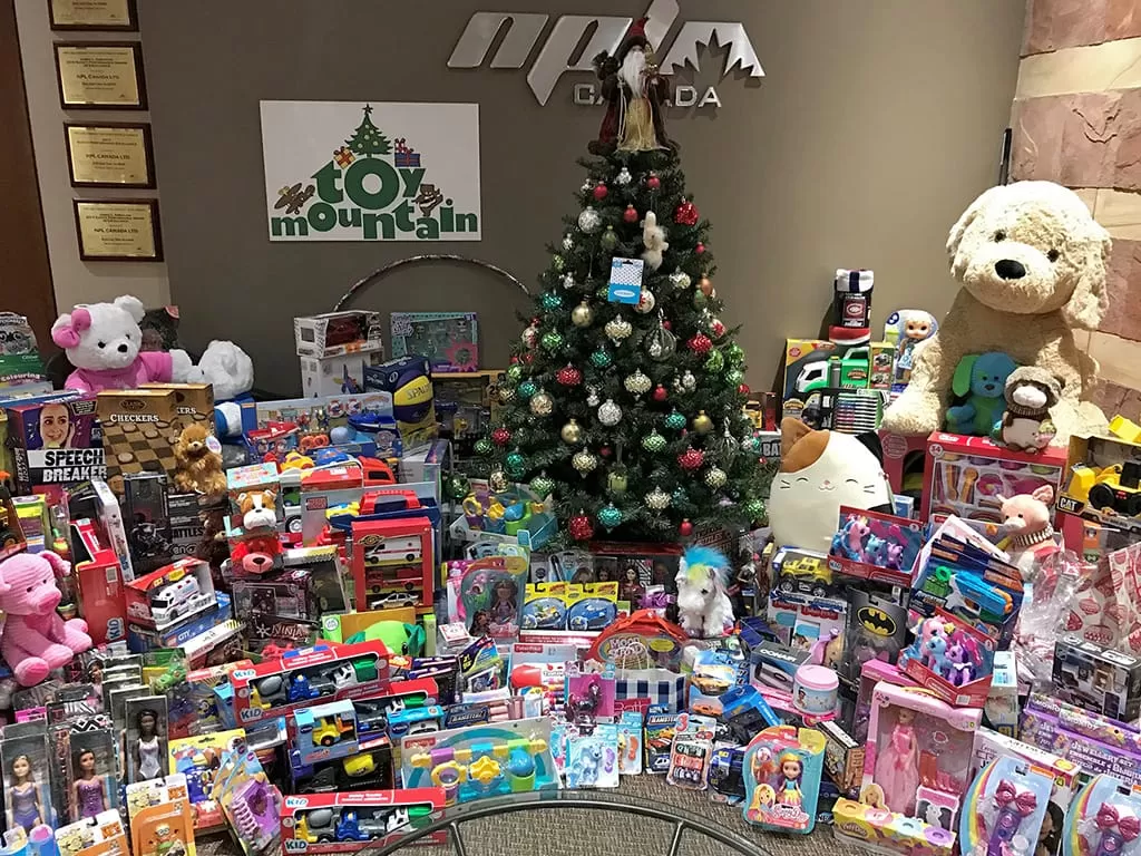 Image of a Christmas tree with lots and lots of toys around it for a toy drive